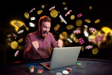 A man celebrating a winning moment on his laptop while gaming symbols float around him, capturing the excitement of TAS71 games.